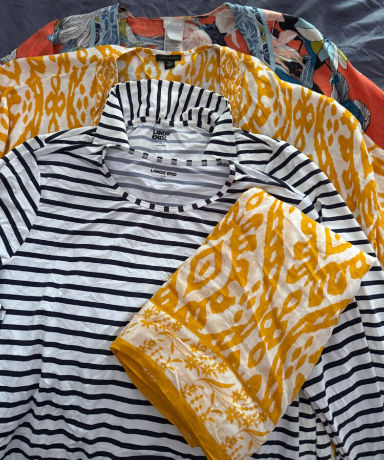 a collection of linen coverups, pareos, and rashguards for women